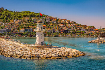 Alanya, Turkey. Old lighthouse in the harbor of the Turkish city and view of the old fortress and...