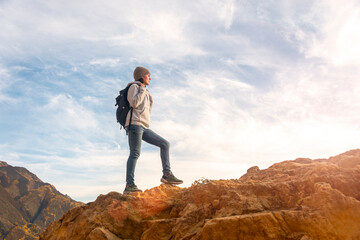 woman hiker with backpack walking up rocks, getting away from it all concept.