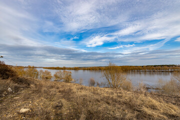 Obraz premium early spring flood, high water in the countryside, river overflowing its banks, trees in the water, flooded banks, environmental pollution, ecology