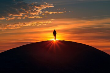 Silhouette of a lone figure standing on a hilltop against a dramatic sunset sky, with sun rays piercing the horizon