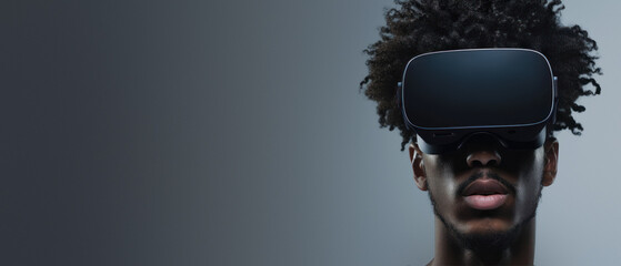 An edgy man with curly hair is depicted wearing virtual reality glasses, posing in a sleek grey setting - 750890155