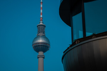 Tv tower in Berlin, on Alexanderplatz square on a clear spring day. Prominent tall building in Berlin, Germany. Looking from side compared to other building