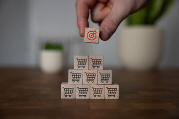 Sale volume increase make business goal success, Wood cube with icon goal and shopping cart symbol.