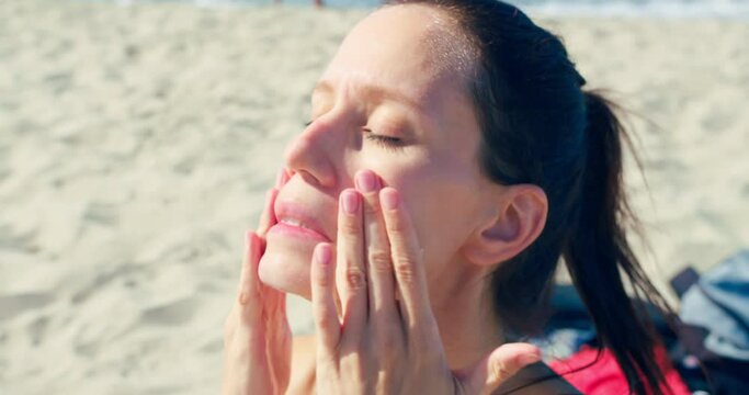 Close-up woman face takes sunscreen, moisturizing lotion applies sunblock on her face, person using good spf skincare for protection before sunbath