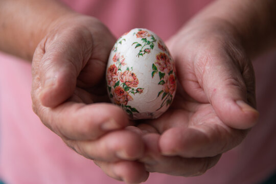 De frente manos sosteniendo huevo de pascua decorado