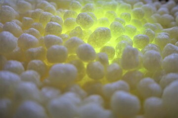 polystirene balls , yellow glowing light ,  textured  background