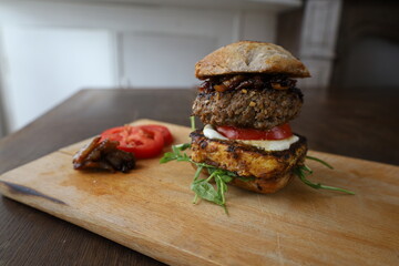 large homemade burger on wooden board