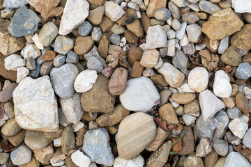Small pebbles of various sizes and colors in a river in northern Italy. Photo taken from above in winter.