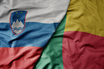 big waving national colorful flag of benin and national flag of slovenia.