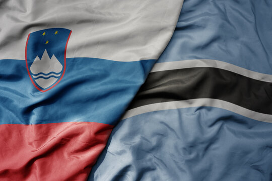 big waving national colorful flag of botswana and national flag of slovenia.