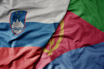 big waving national colorful flag of eritrea and national flag of slovenia.