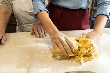 Closeup of a young girl in the kitchen kneading the dough to make donuts, a traditional dessert in Spain for Christmas.