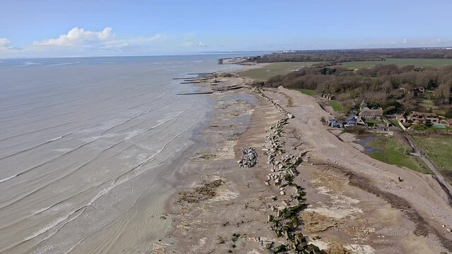 Atherington and Climping beach in West Sussex and the broken sea defence and the temporary shingle bank in place to protect the land, aerial video.