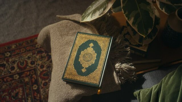 No people flat lay footage of holy blessed book of Quran in green hard cover and decorated with gold ornaments ling on small table indoors