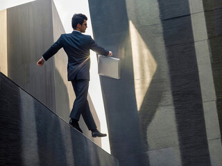 Film grain effect, Businessman in suit with briefcase in hand stumbles on edge, concept loses balance in business