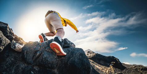 Male hiker climbing the mountain - Strong hiker standing on the top of the cliff enjoying sunset view - Extreme sport life style concept - obrazy, fototapety, plakaty