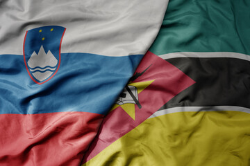 big waving national colorful flag of mozambique and national flag of slovenia.