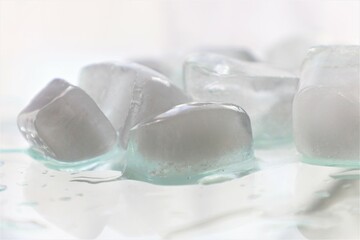 Fototapeta na wymiar melting ice cubes on bright reflective surface