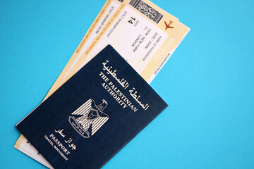 Blue Palestinian Authority passport with airline tickets on blue background close up. Tourism and travel concept