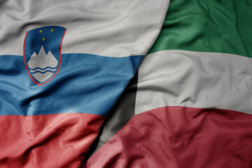 big waving national colorful flag of kuwait and national flag of slovenia.