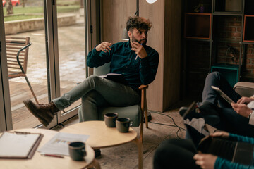 Handsome male business person gesticulating with his hands while explaining colleague