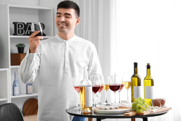 Fototapeta na wymiar Young sommelier with glasses of wine in kitchen