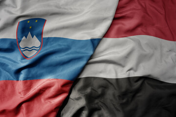 Fototapeta premium big waving national colorful flag of yemen and national flag of slovenia.
