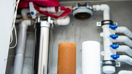 Old and new water filters on filter system background. Plumbing water filter cartridge replace...