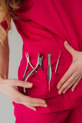 The girl holds manicure tools in her pocket. Style. Nail clippers, pusher.