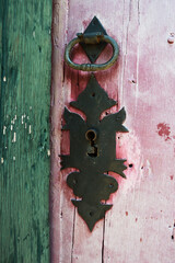 Vertical image of lock and bolt on wooden door of historic house