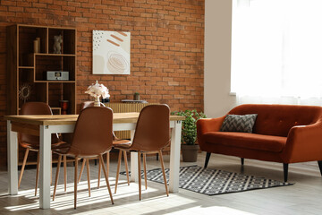 Interior of light living room with table, chairs, sofa and shelving unit