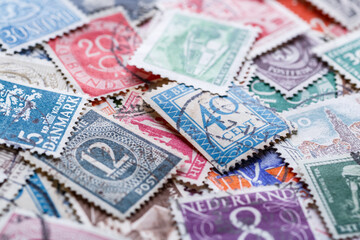 Postage stamps.A collection of world stamps in a pile.Postage stamps from different countries and times - obrazy, fototapety, plakaty