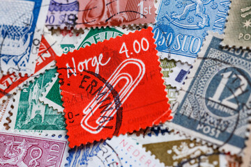 Ukraine, Kiyiv - January 12, 2023 Clip on norwegian postage stamp.Postage stamps.A collection of world stamps in a pile.Postage stamps from different countries and times