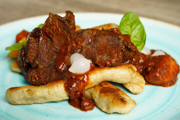 Cooked beef with vegetables on a wooden table