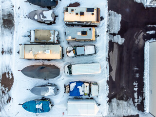 Drone view of camper, mobile home, and boat winter storage.