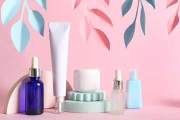 Facial cosmetic products composition with paper flowers on pink background