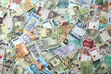 Many banknotes of different currency. Background of big amount of random money bills close up