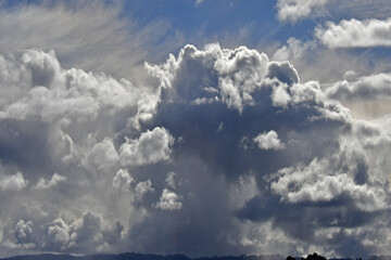 Cloudscape with Cirrus at altitude and cumulonimbus thunderheads at lower level dropping rain