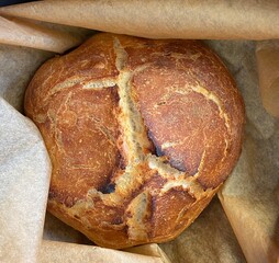Sourdough bread half packed in paper, top view