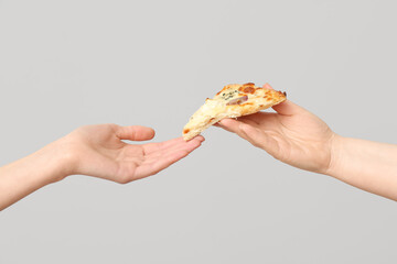 Female hand giving tasty pizza slice on white background