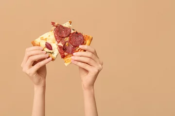 Fototapeten Female hands holding tasty pizza slices on beige background © Pixel-Shot