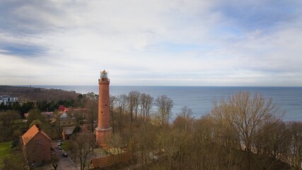 A drone captures Gąski beach, West Pomeranian Voivodeship, Poland, featuring a red brick lighthouse. © Grzegorz