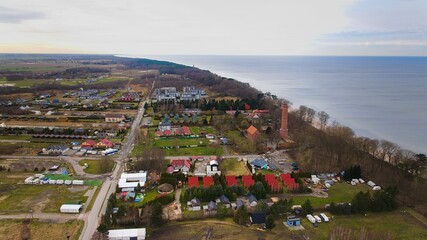 A drone captures Gąski beach, West Pomeranian Voivodeship, Poland, featuring a red brick lighthouse. © Grzegorz