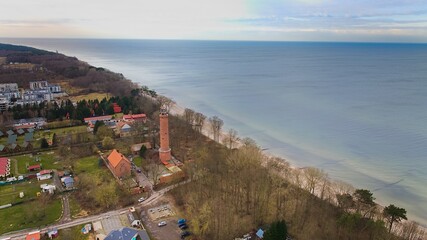 A drone captures Gąski beach, West Pomeranian Voivodeship, Poland, featuring a red brick lighthouse.