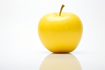 A yellow apple sits on a white background