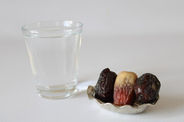 Medina dates and zamzam water in bowl on white background © Abdulkadir