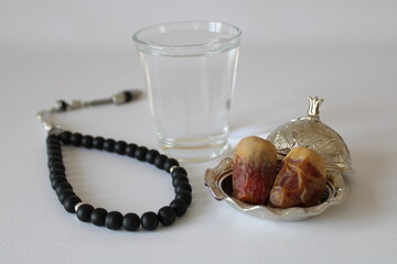 Medina dates and zamzam water in bowl on white background © Abdulkadir
