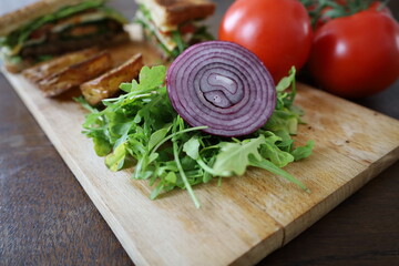 homemade club sandwich with vegetables and baked potatoes