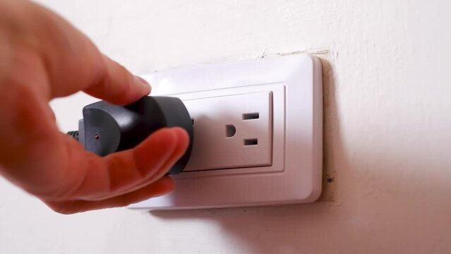 Video of an outlet that connects a white and a black power charger, recharging and electricity theme