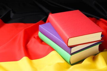 Learning foreign language. Different books on flag of Germany, space for text